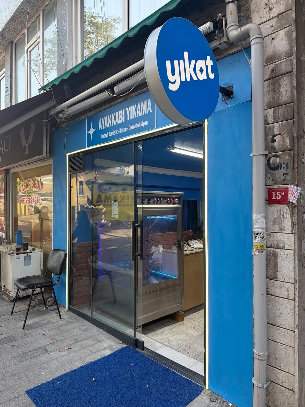 İskele Caddesi No:15-B’deki Yıkat dükkânının mavi tabelası ve giriş kapısı